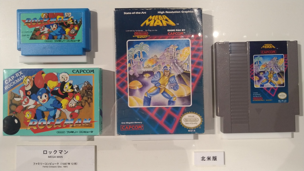 A picture of the Japanese and American boxes for Megaman / Rockman. The Japanese box is cartoonish and cute. The American box tries to go for a realistic aesthetic, to terrible results